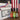Three bottles of the Red, White & Burn Box (Pepper X Trio) are shown before a U.S. flag beside a white box labeled with the product name and a striped ribbon—ideal for adding fiery patriotic flair to your 4th of July celebration.